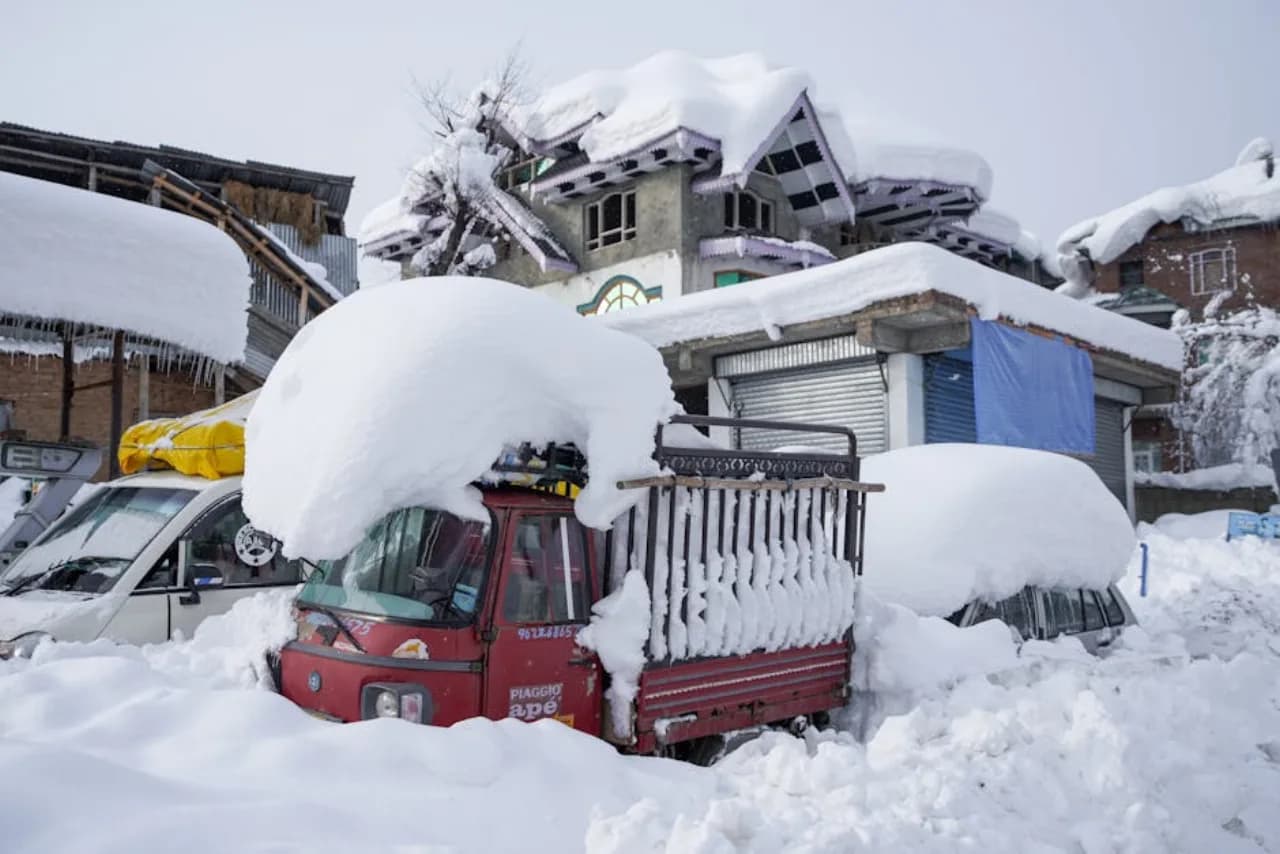 Heavy snow accumulation on a Canadian residential roof with ice dam at the eave — roof snow load safety warning sign.