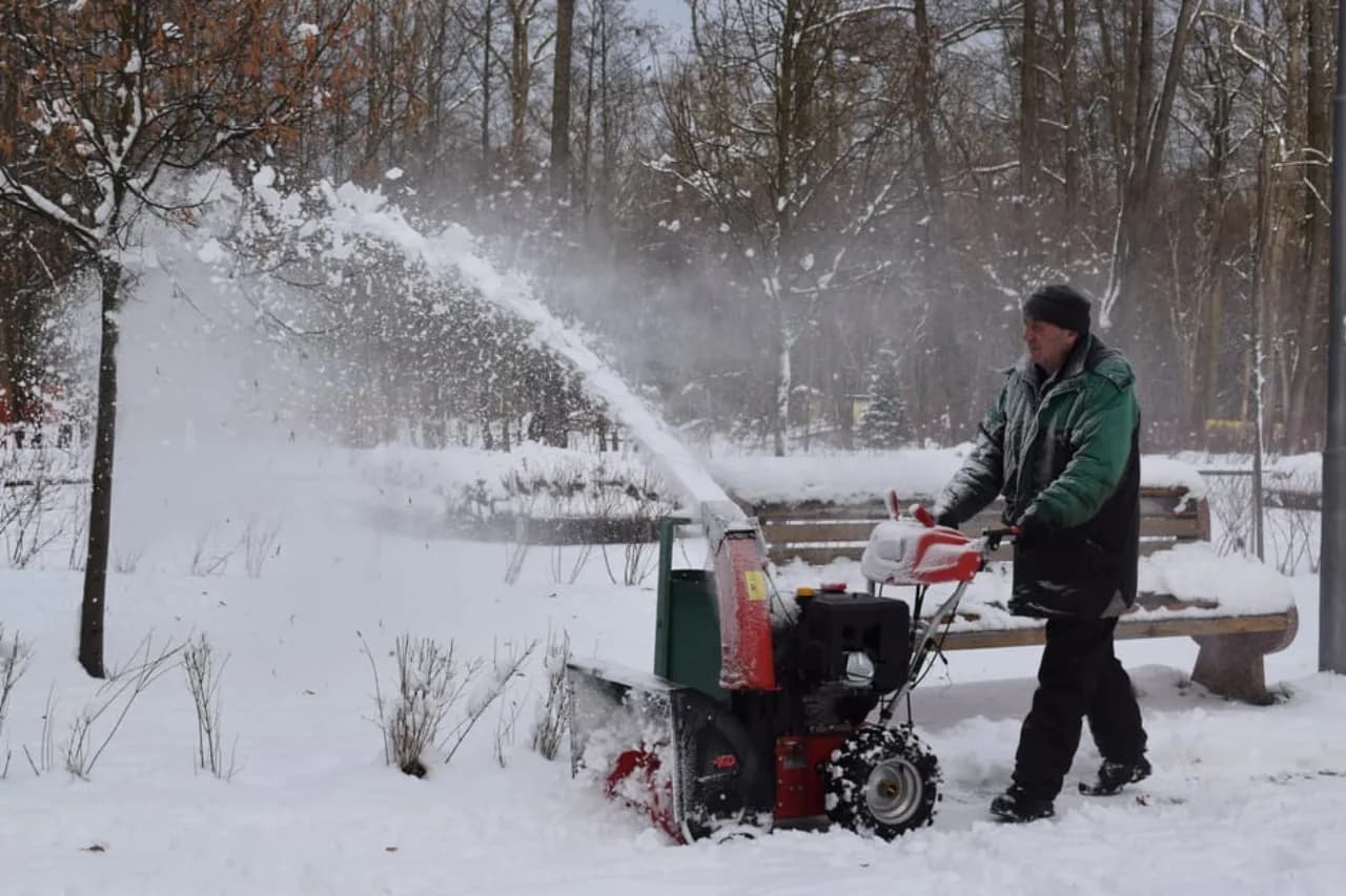 Un opérateur canadien utilise une souffleuse à deux étages à essence projetant un haut panache de neige dans un parc enneigé — contexte de tests produits pour les comparaisons d’équipement snow.ca.