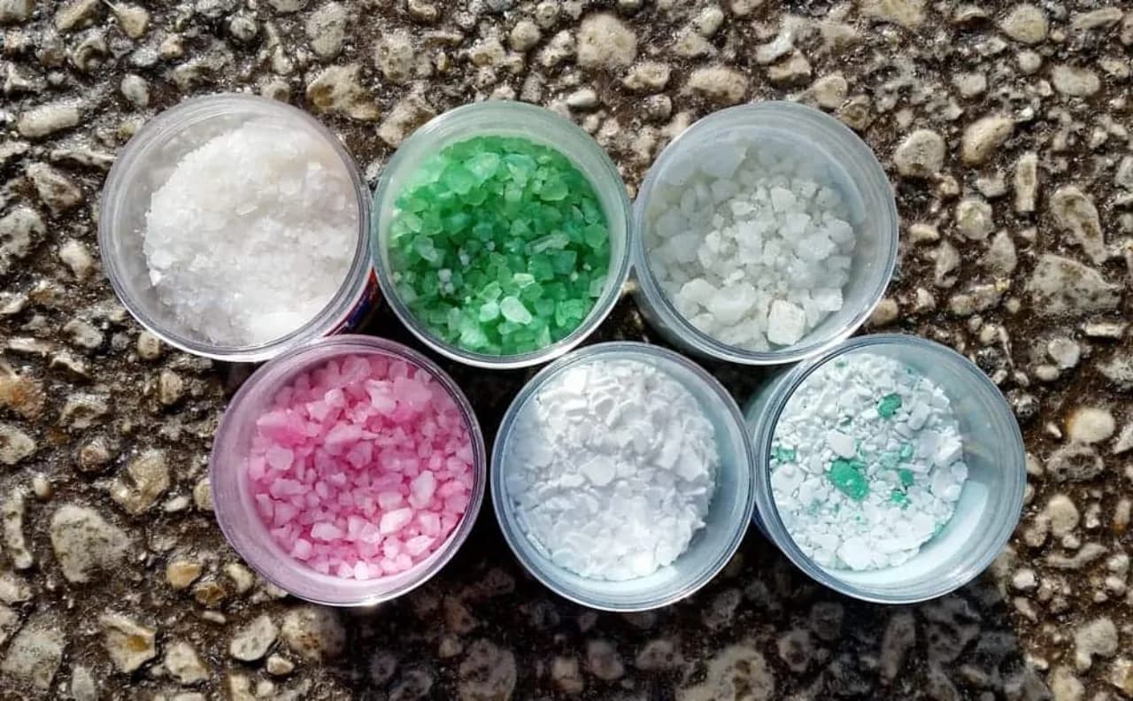 Six bowls comparing de-icer blends — rock salt, treated green and pink chlorides, calcium-chloride flakes and magnesium pellets — the snow.ca product catalog of Canadian commercial de-icers for parking lots and walkways.