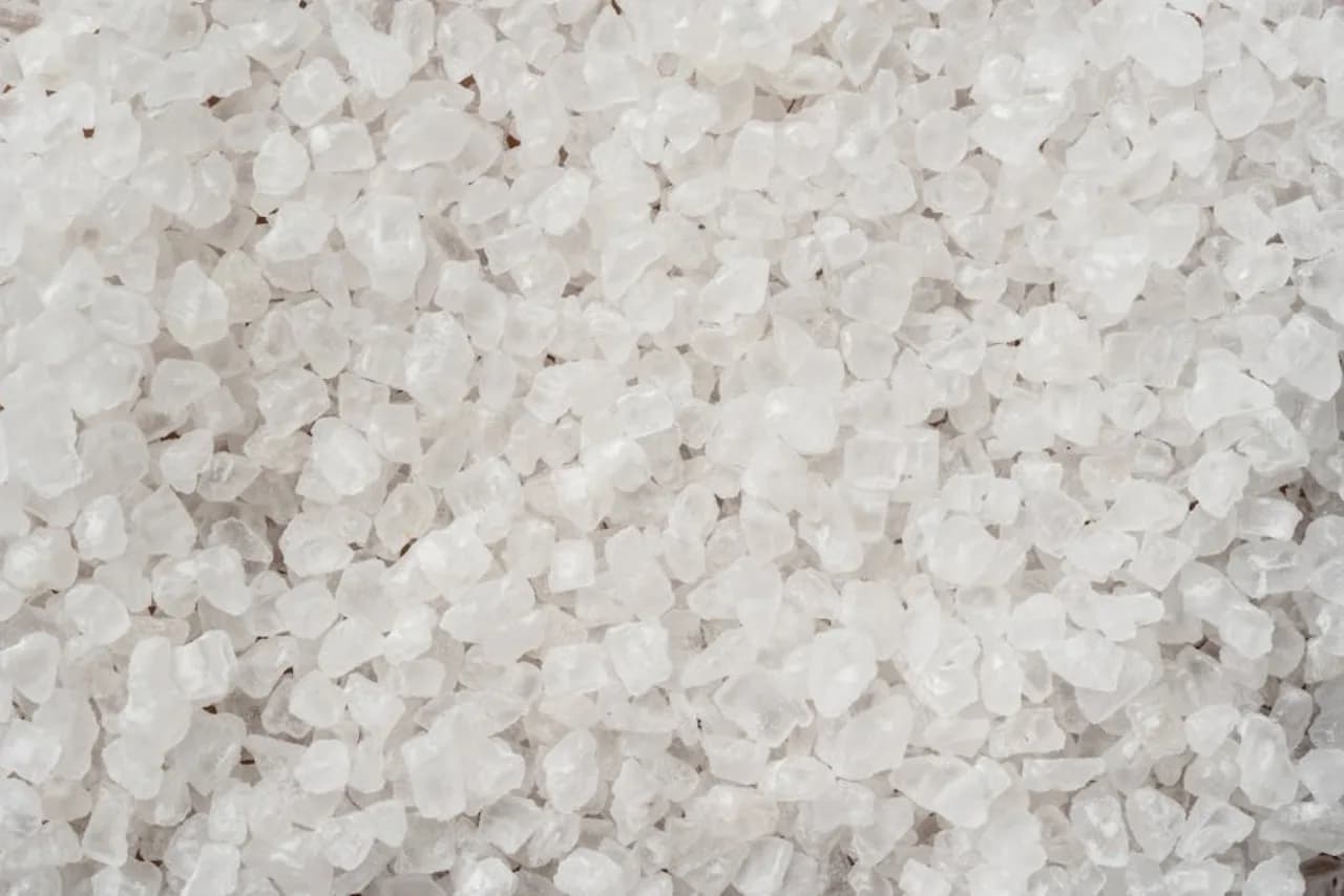 Bulk highway-grade rock salt crystals in macro view — coarse sodium chloride de-icer stockpile for Canadian commercial and municipal snow.ca accounts.