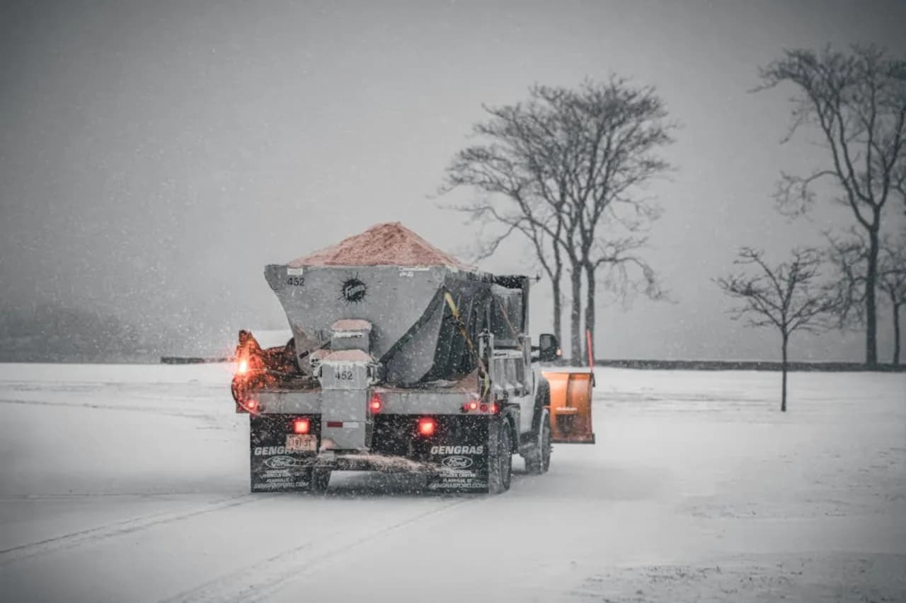 Salt spreader truck applying de-icing salt to a Canadian commercial parking lot — calibrated, documented.