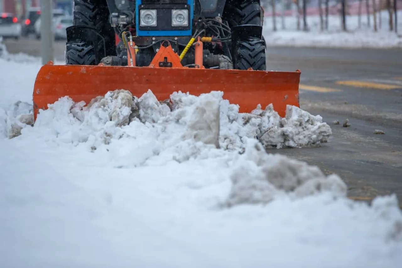 Snow removal in progress on a Canadian residential driveway — truck-mounted plow, GPS-tracked crew, photo proof.